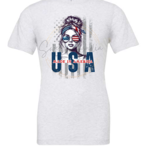 Photo shows a shirt with a heat-pressed design. The design is of a girl with a bun wearing USA colored glasses. A text across the design reads: Made in America. USA